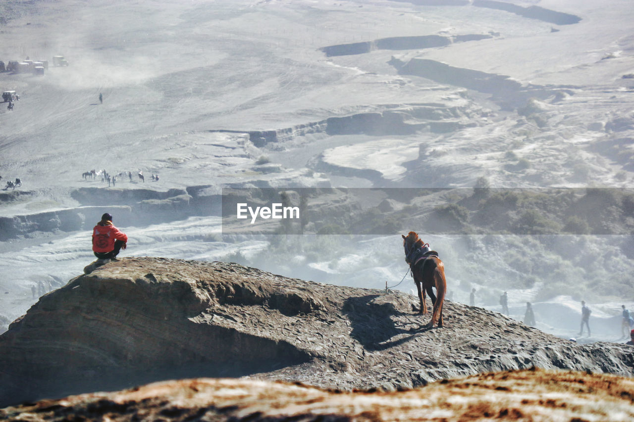 Person and horse on mountain against landscape