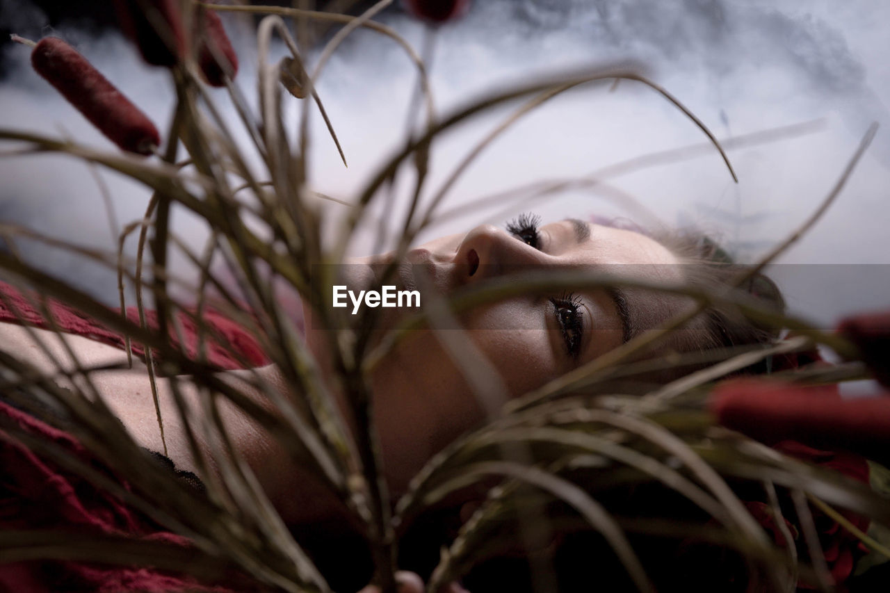 Close-up of woman lying by grass