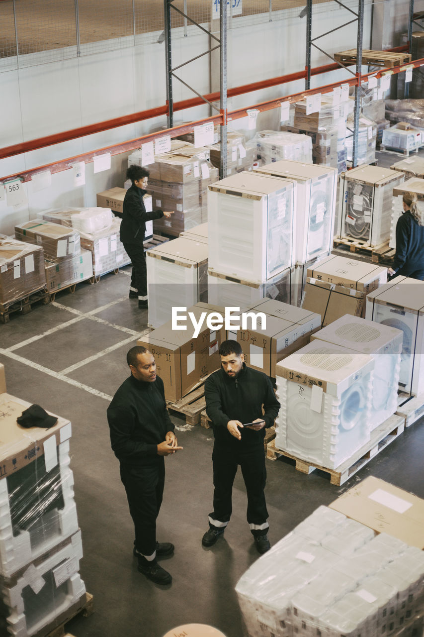 High angle view of manual workers working in logistics warehouse