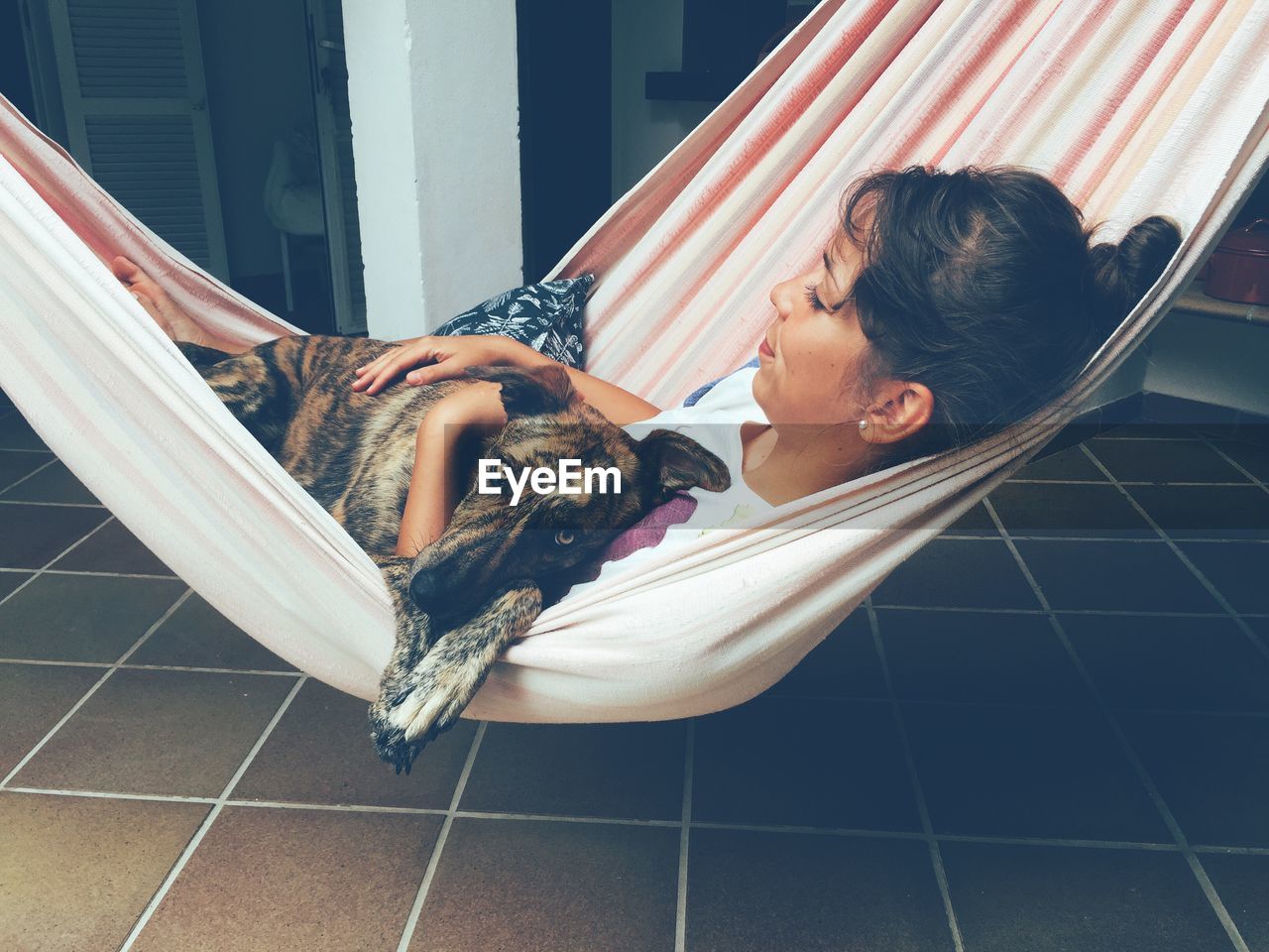 Woman relaxing in hammock with her dog
