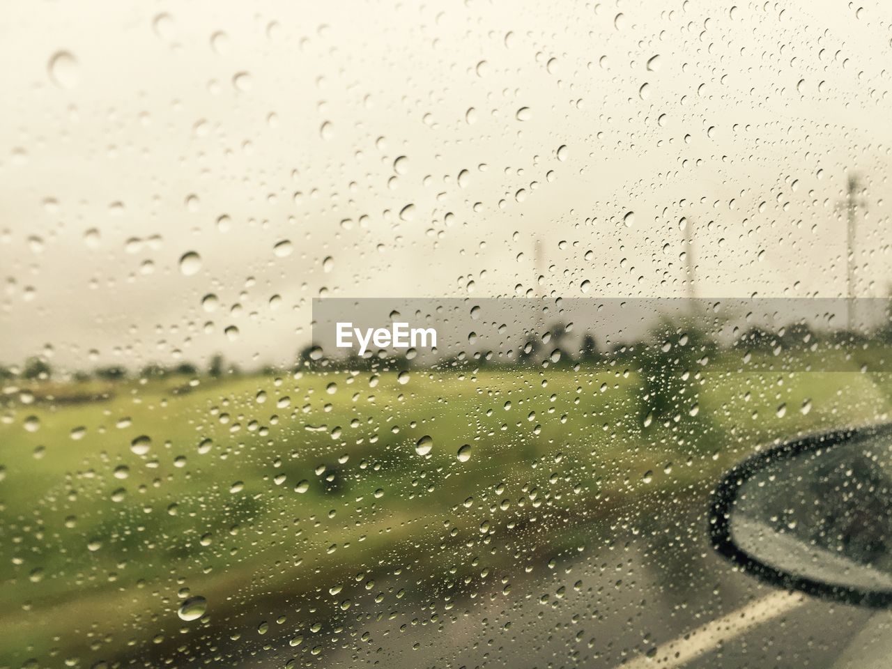 CLOSE-UP OF WET CAR WINDOW AGAINST SKY