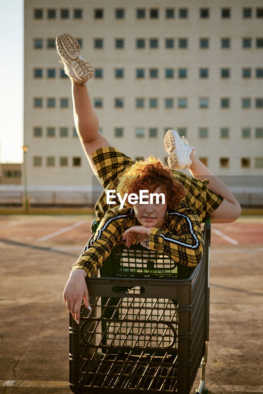 Alternative redhead with yellow shirt and a shopping cart