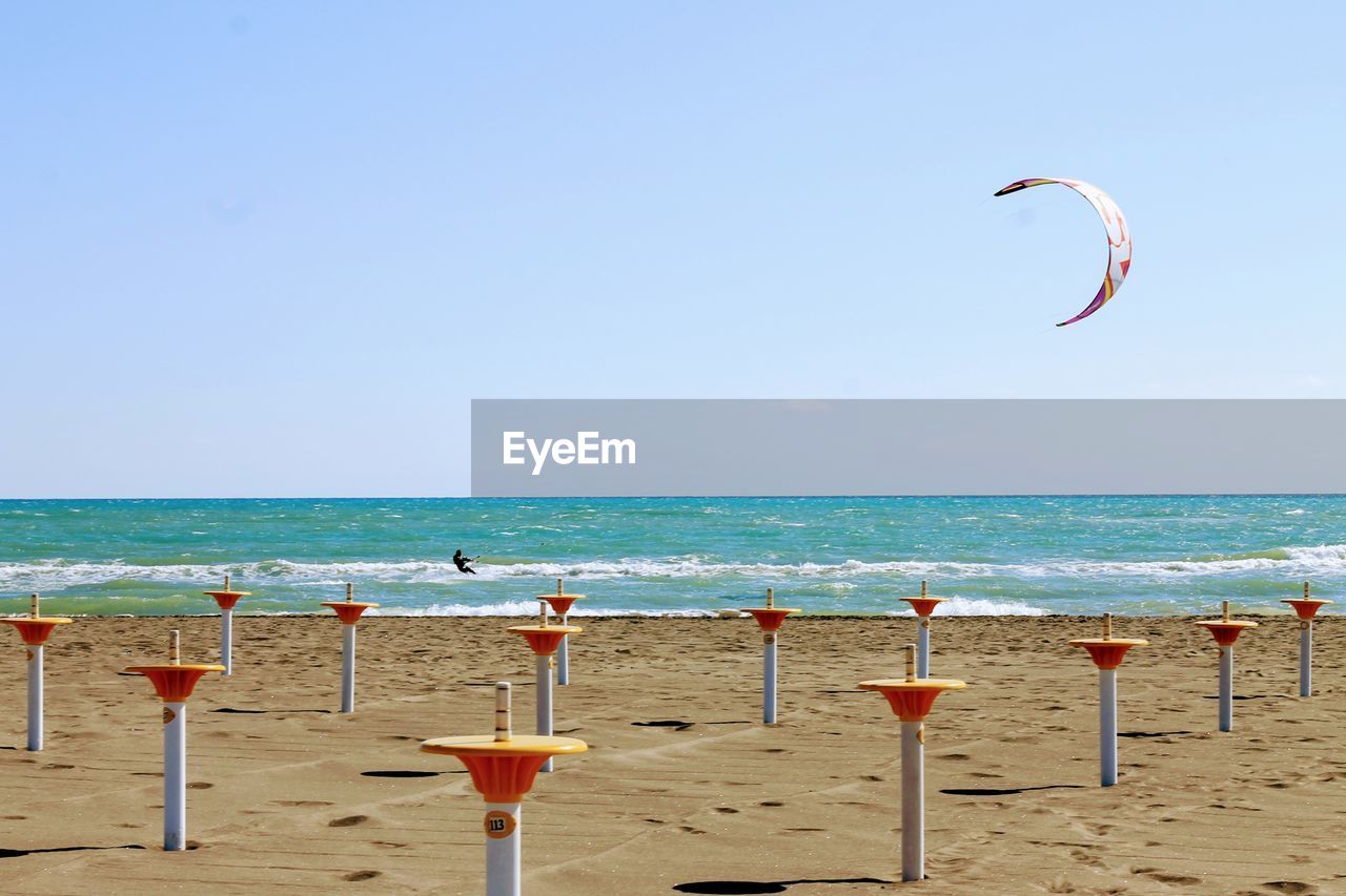 Bollards at beach against clear sky