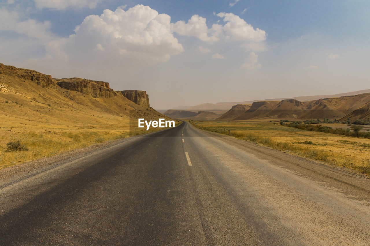 EMPTY ROAD LEADING TOWARDS MOUNTAIN AGAINST SKY