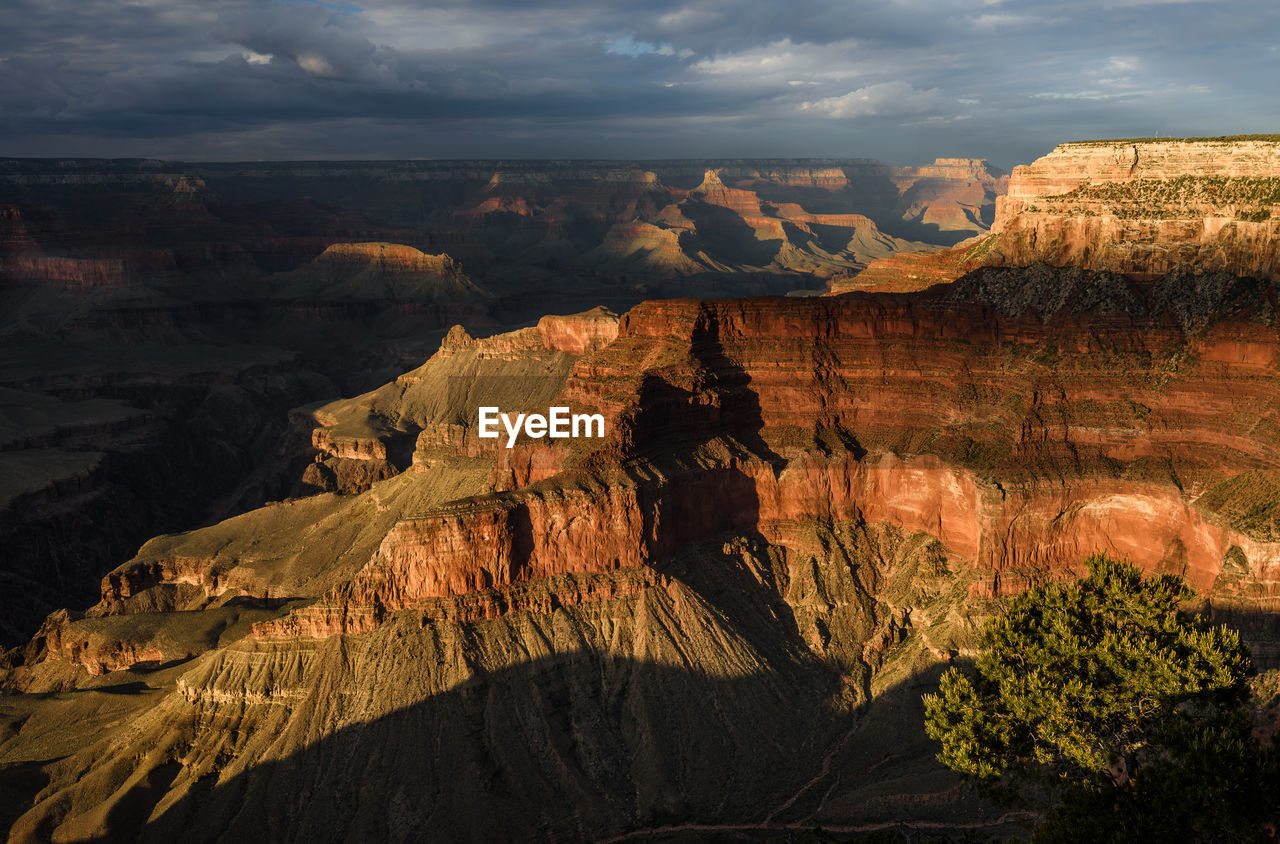 Scenic view of rock formations against cloudy sky