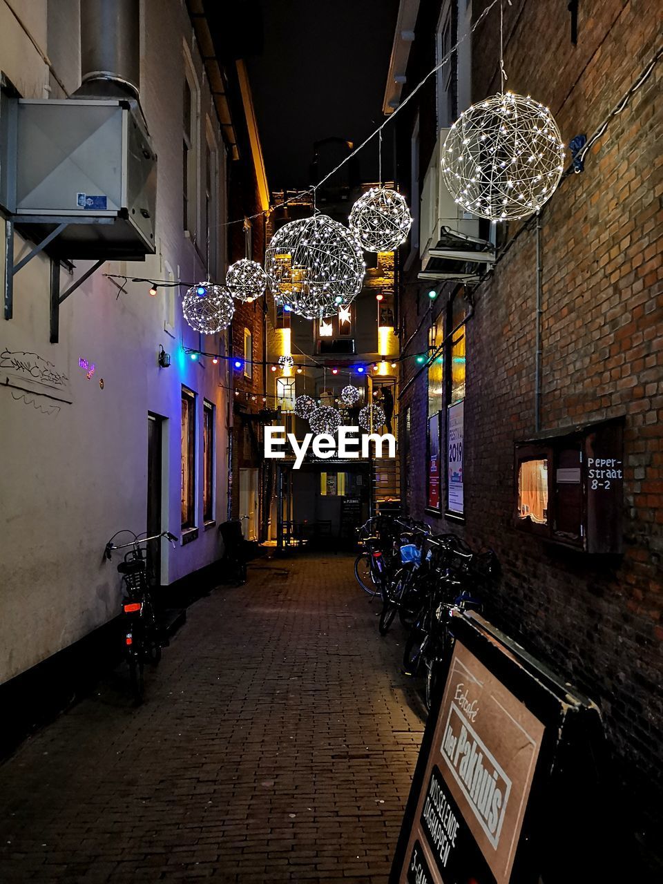 ILLUMINATED LANTERNS HANGING ON STREET IN CITY