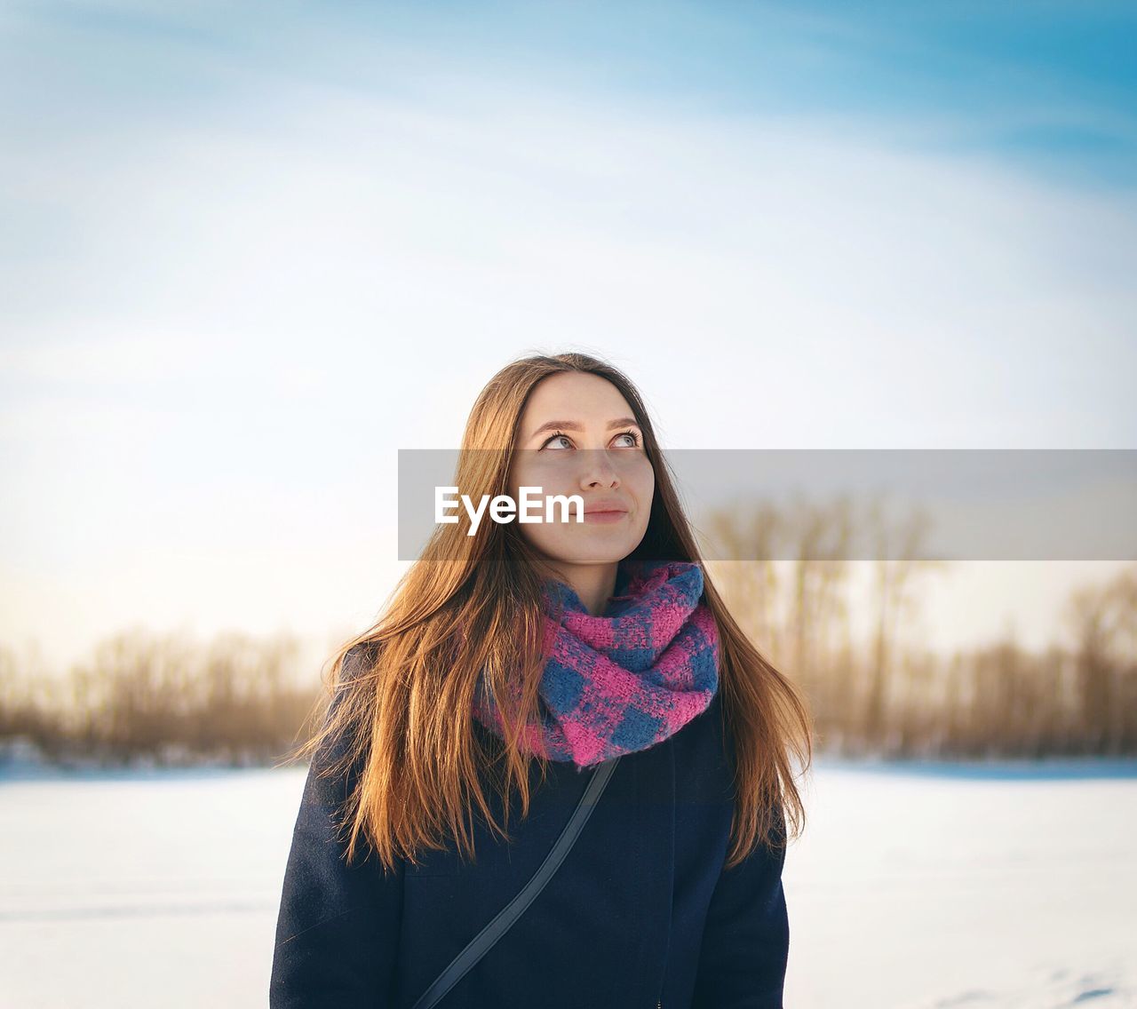 Thoughtful young woman standing outdoors during winter