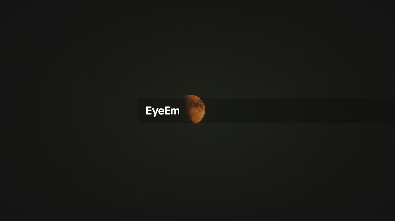 Low angle view of moon in dark sky