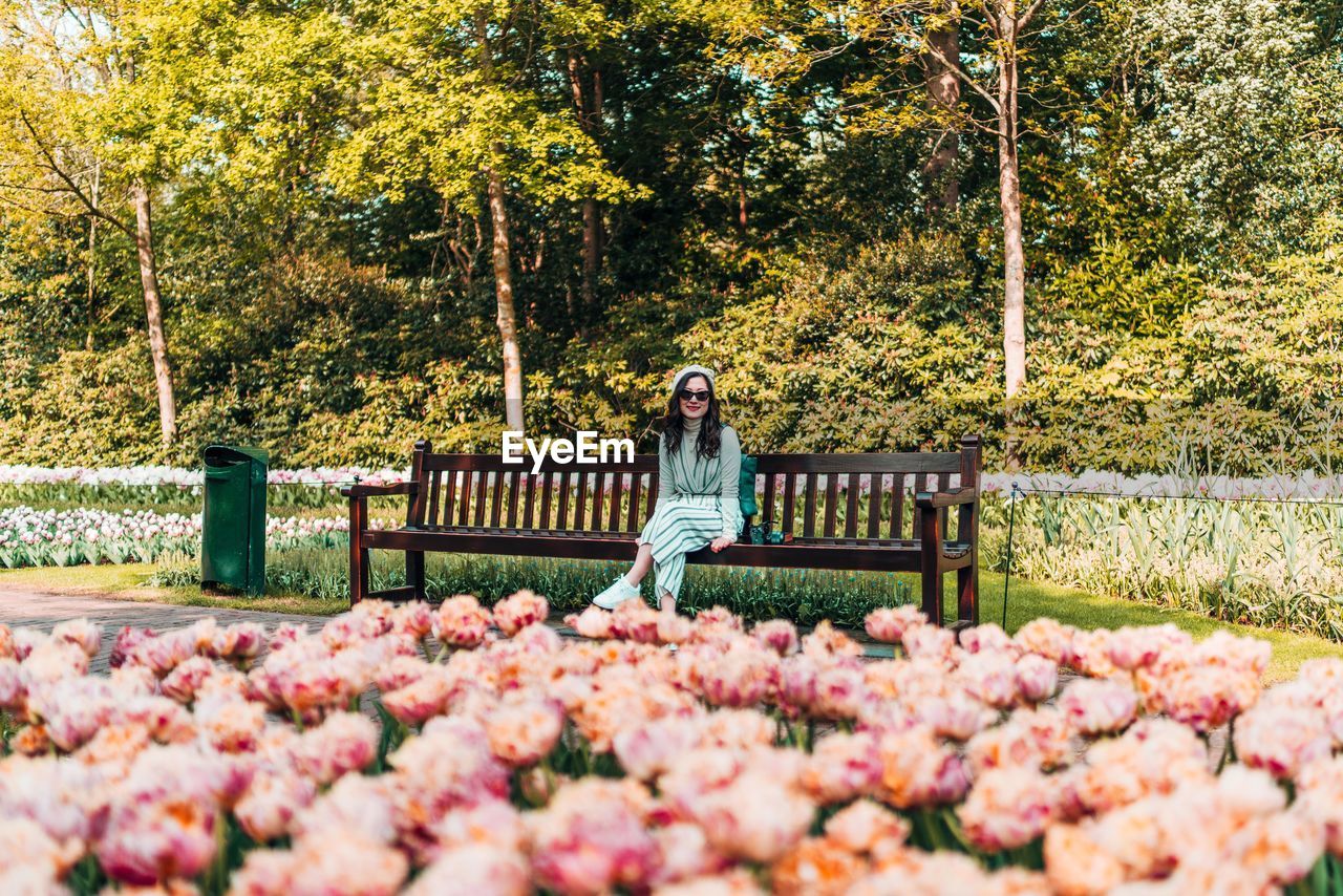 Portrait of woman sitting on bench in park