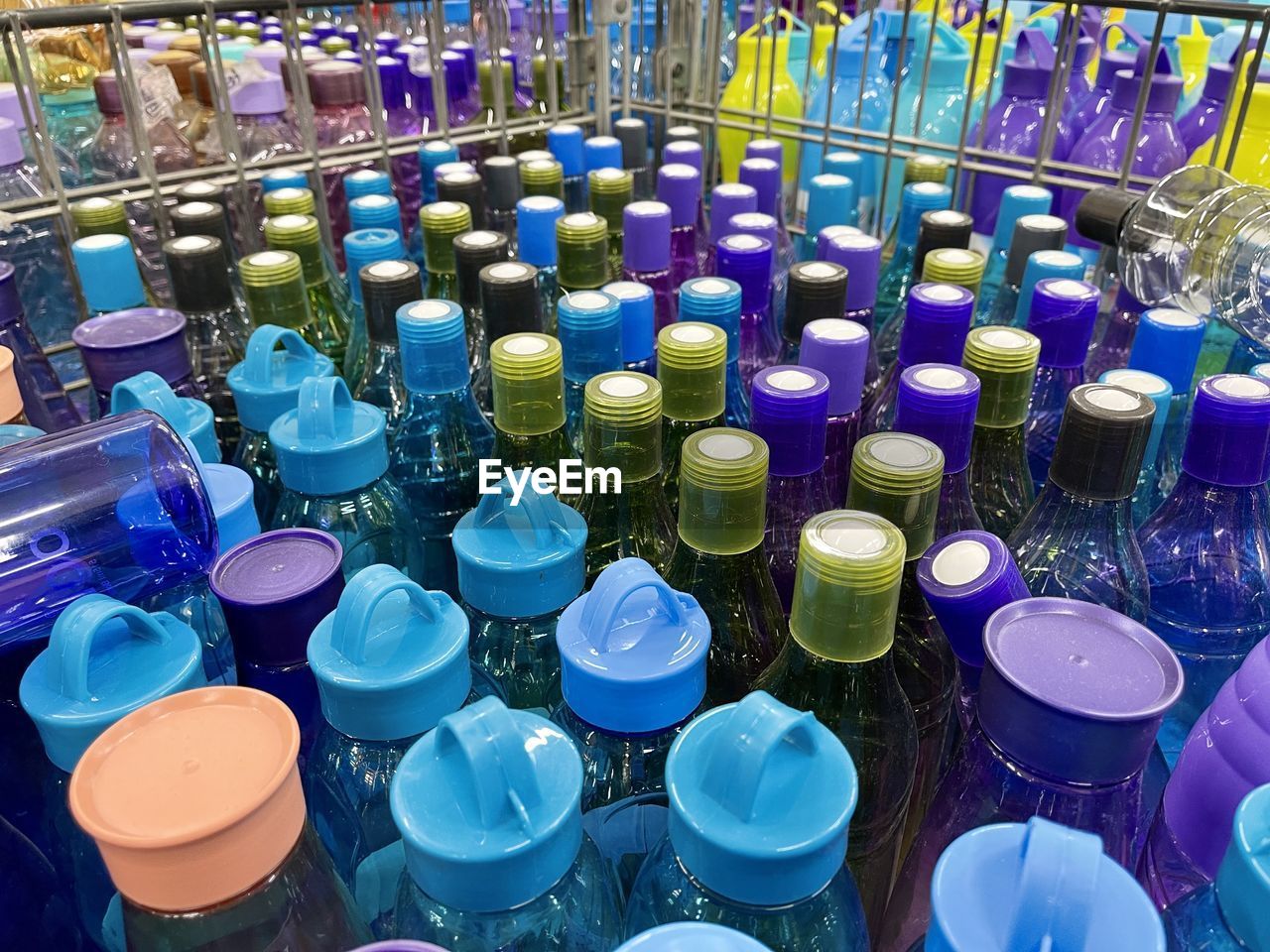 HIGH ANGLE VIEW OF MULTI COLORED BOTTLES IN GLASS