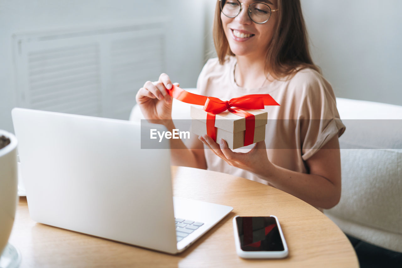 Young woman in glasses doing online shopping on a laptop at home