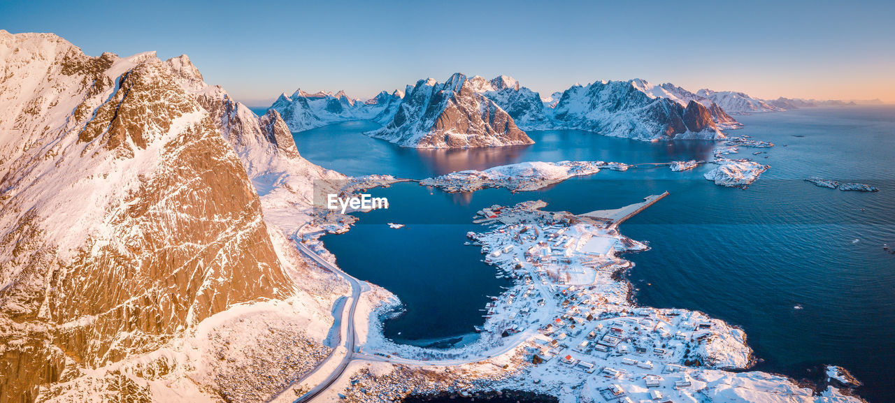 Scenic view of mountains by sea against clear sky