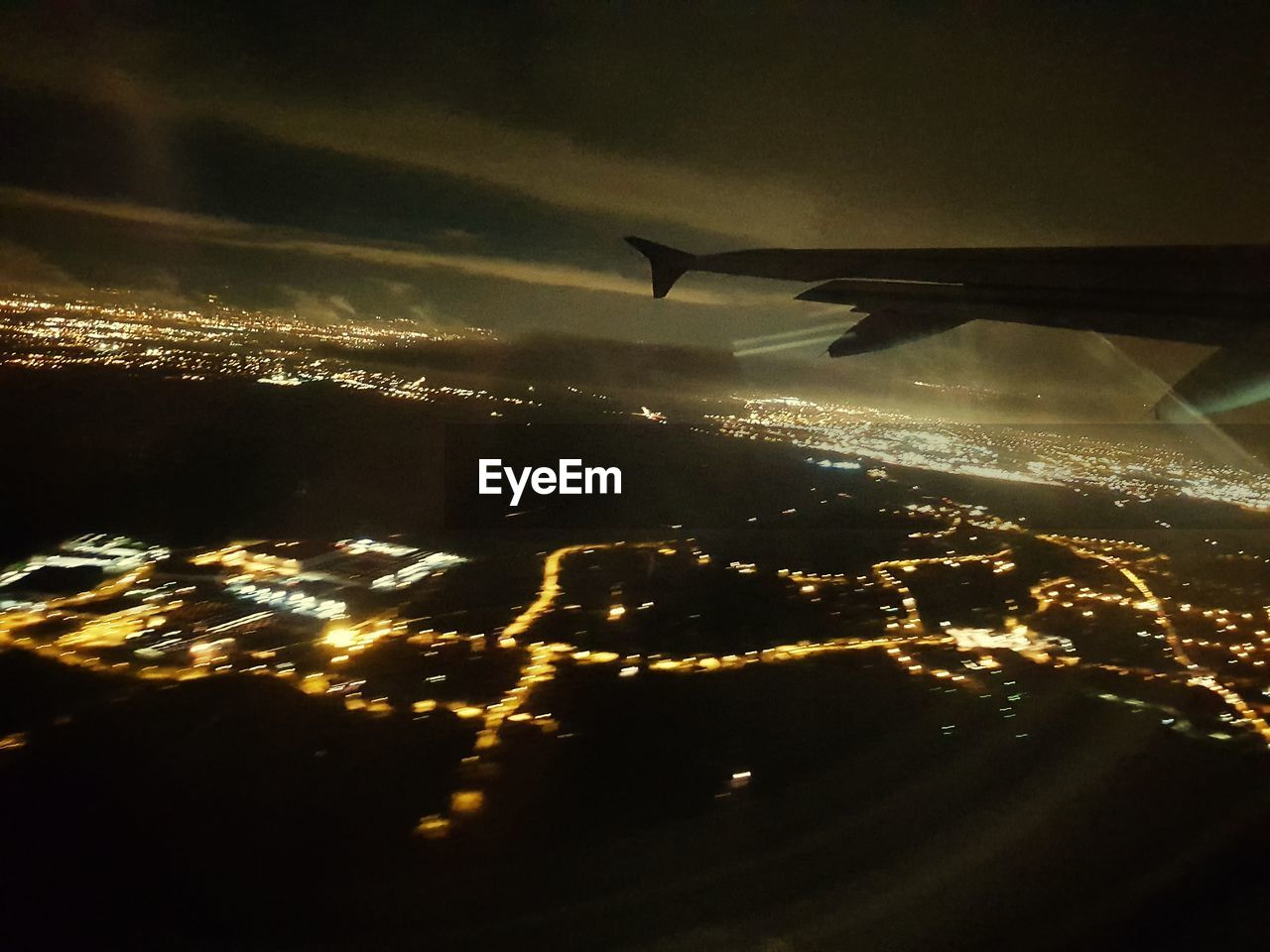 AERIAL VIEW OF ILLUMINATED AIRPLANE AT NIGHT