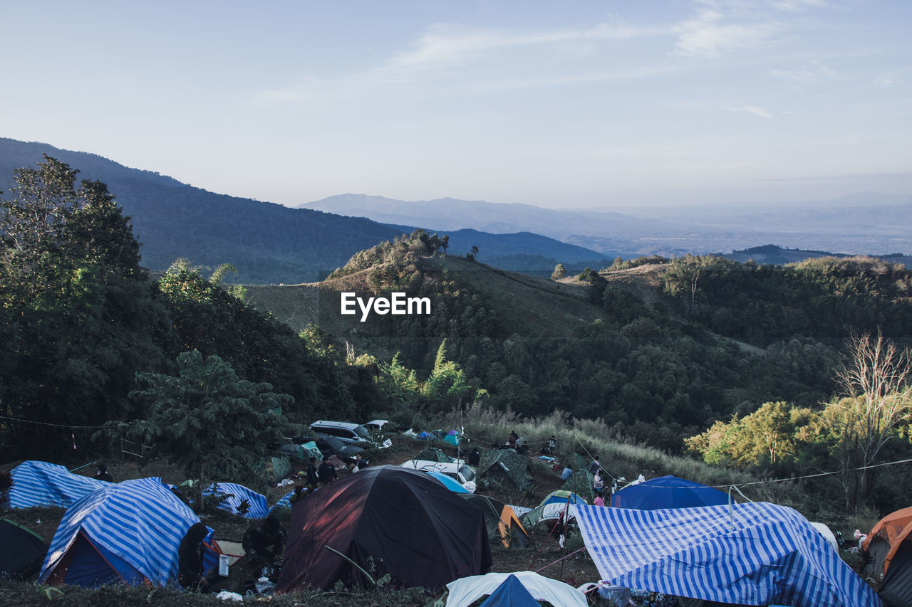 High angle view of tents on mountain in forest against sky