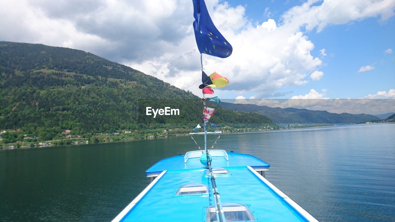 View of boat in calm lake with mountains in background