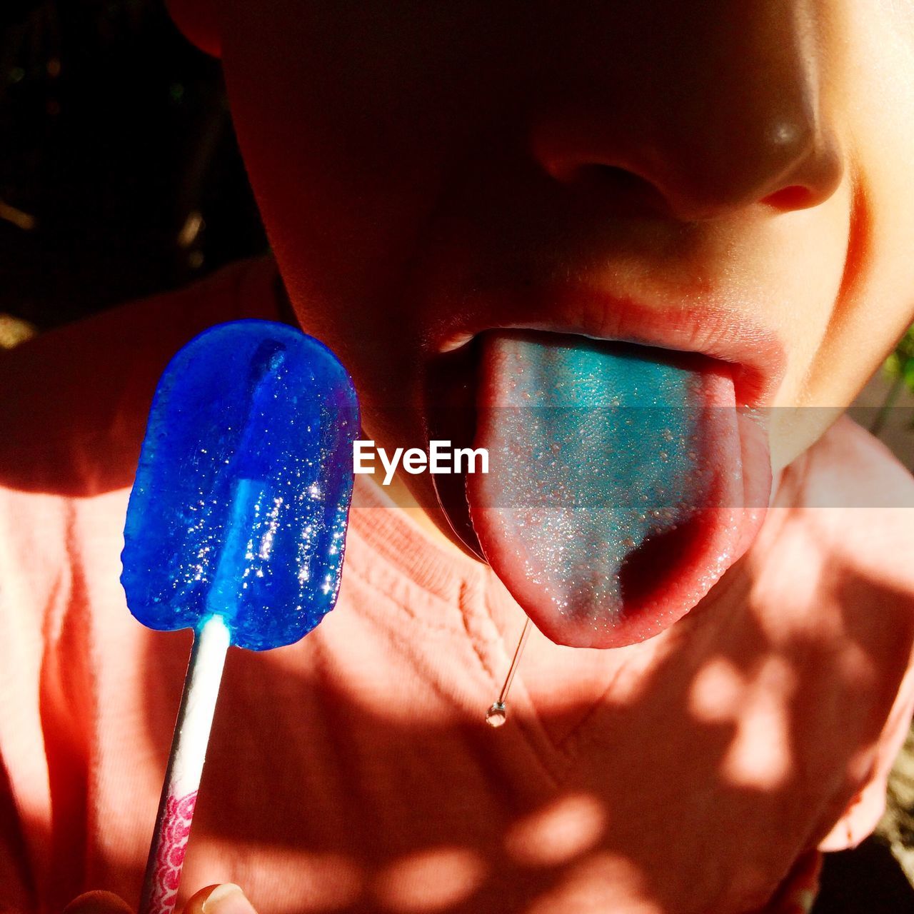 Close-up of boy sticking out tongue while holding flavored ice