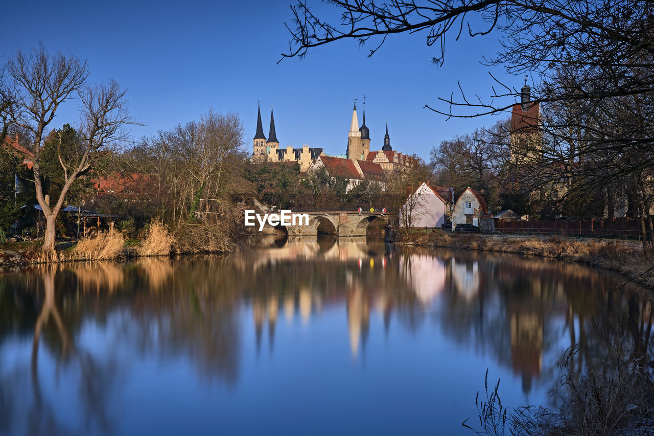 REFLECTION OF TREES AND BUILDINGS ON LAKE