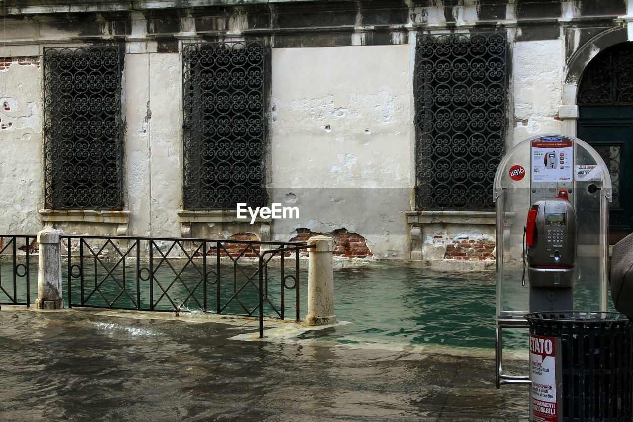 Telephone booth by canal in city