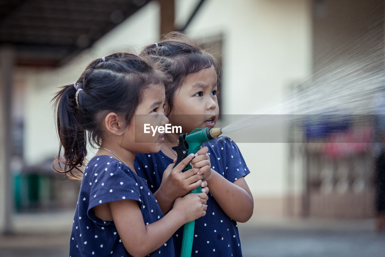 Siblings spraying water