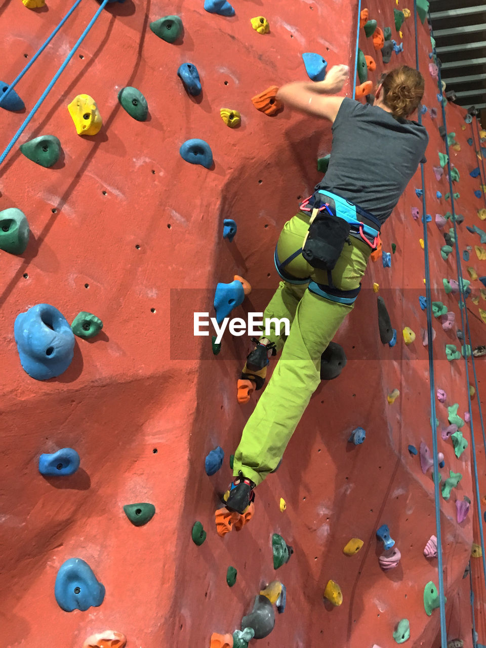 Rear view full length of woman climbing wall