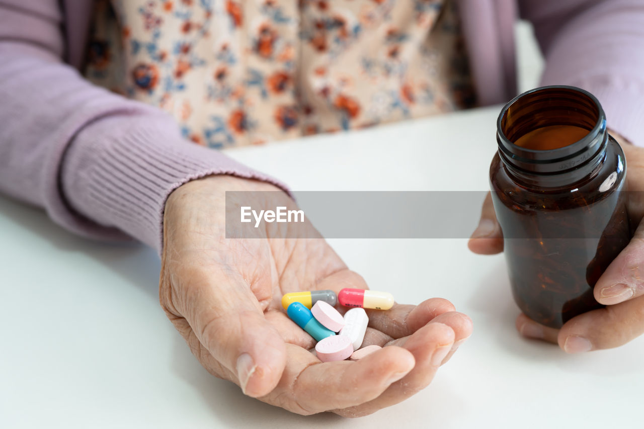 cropped hand of woman with pills