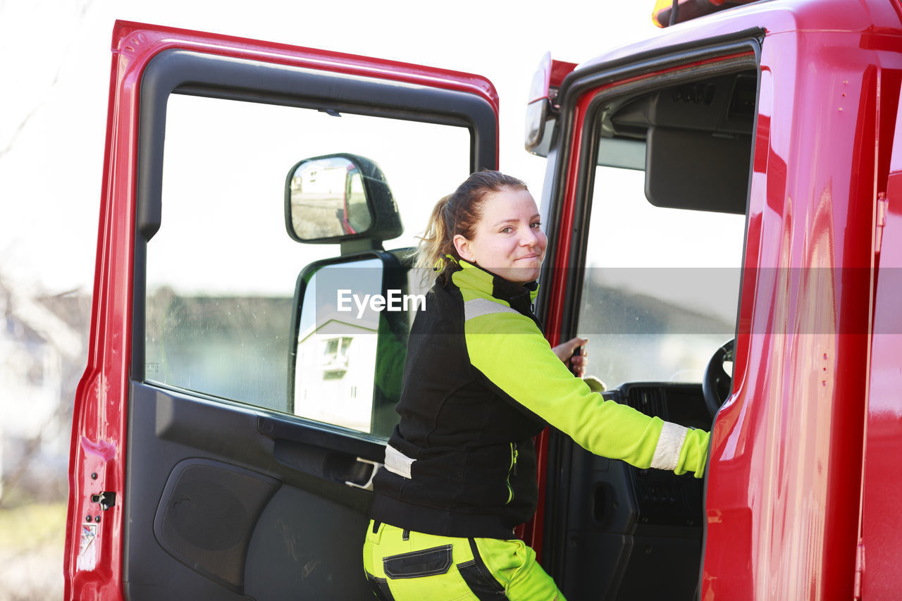 Woman entering garbage truck