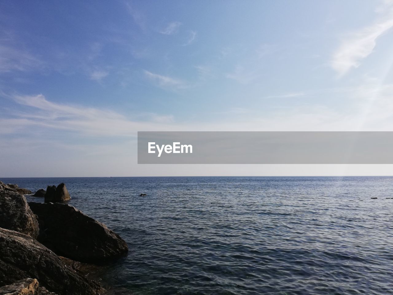 SCENIC VIEW OF ROCKS IN SEA AGAINST BLUE SKY