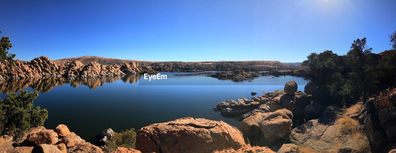 Scenic view of lake against clear blue sky