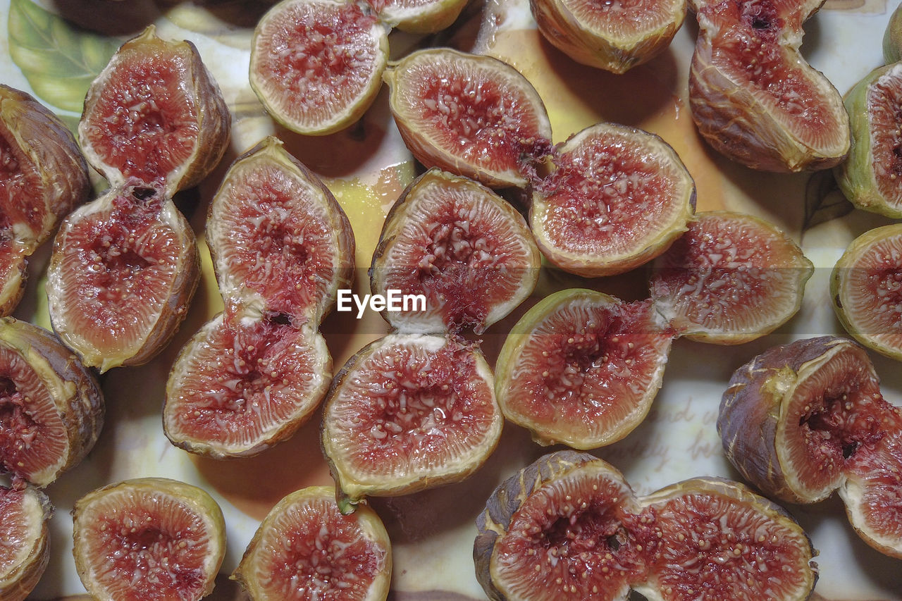 food, food and drink, common fig, freshness, plant, fruit, healthy eating, wellbeing, produce, fig, no people, slice, large group of objects, indoors, cross section, red, still life, high angle view, abundance, close-up