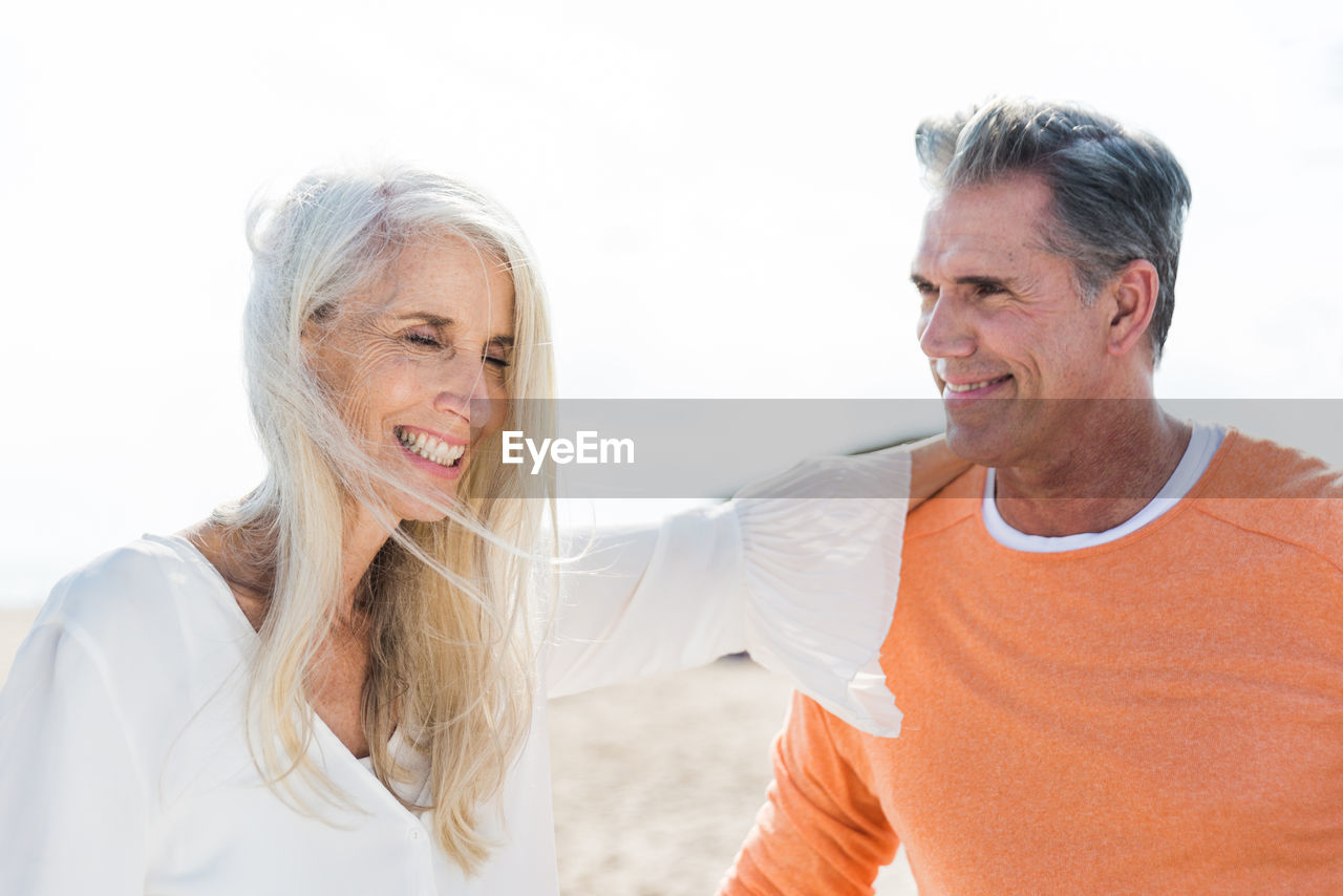 Smiling couple standing at beach