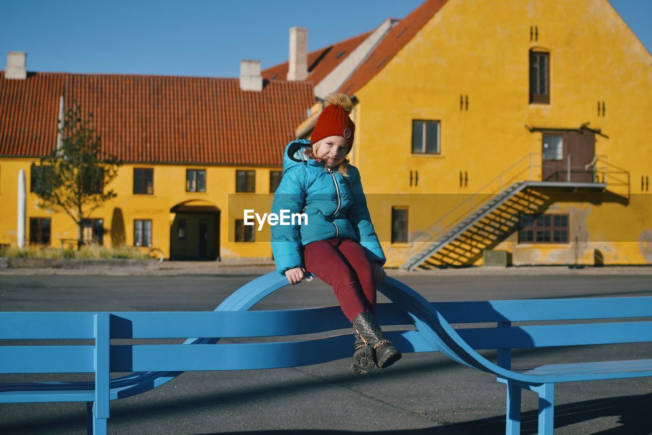 Full length of girl on playground against building