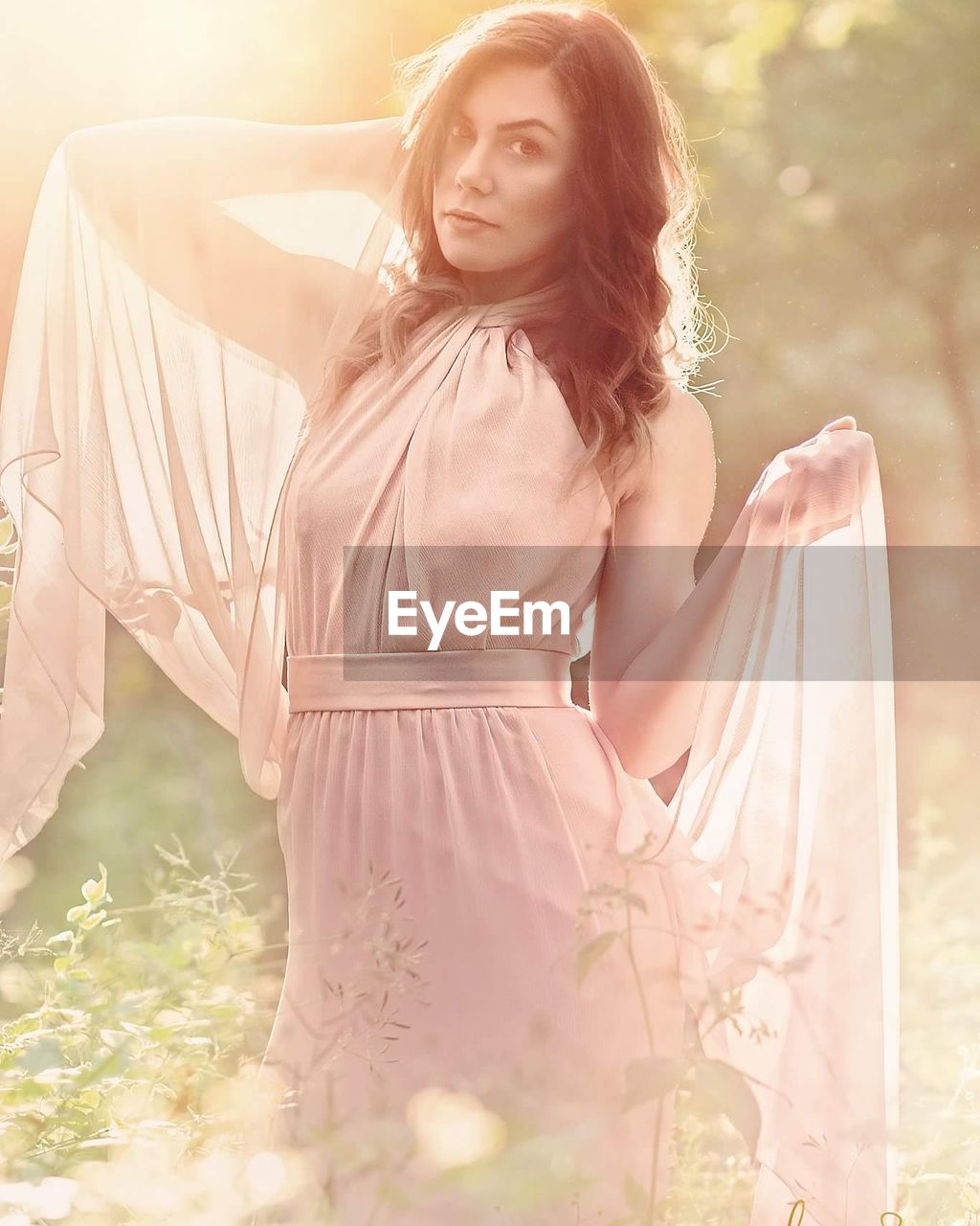 Beautiful woman wearing dress while standing at park on sunny day