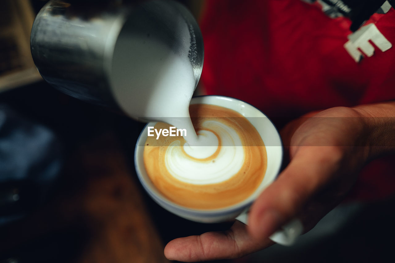 cropped hand of woman holding coffee