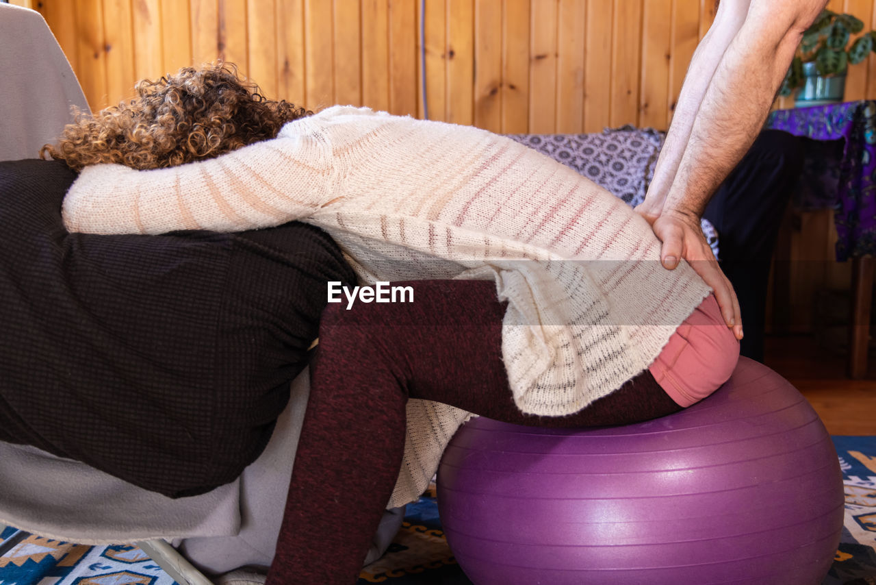 low section of woman sitting on chair at home