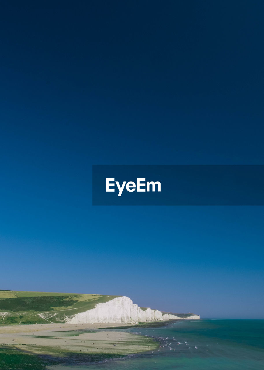 Scenic view of seven sisters against clear blue sky