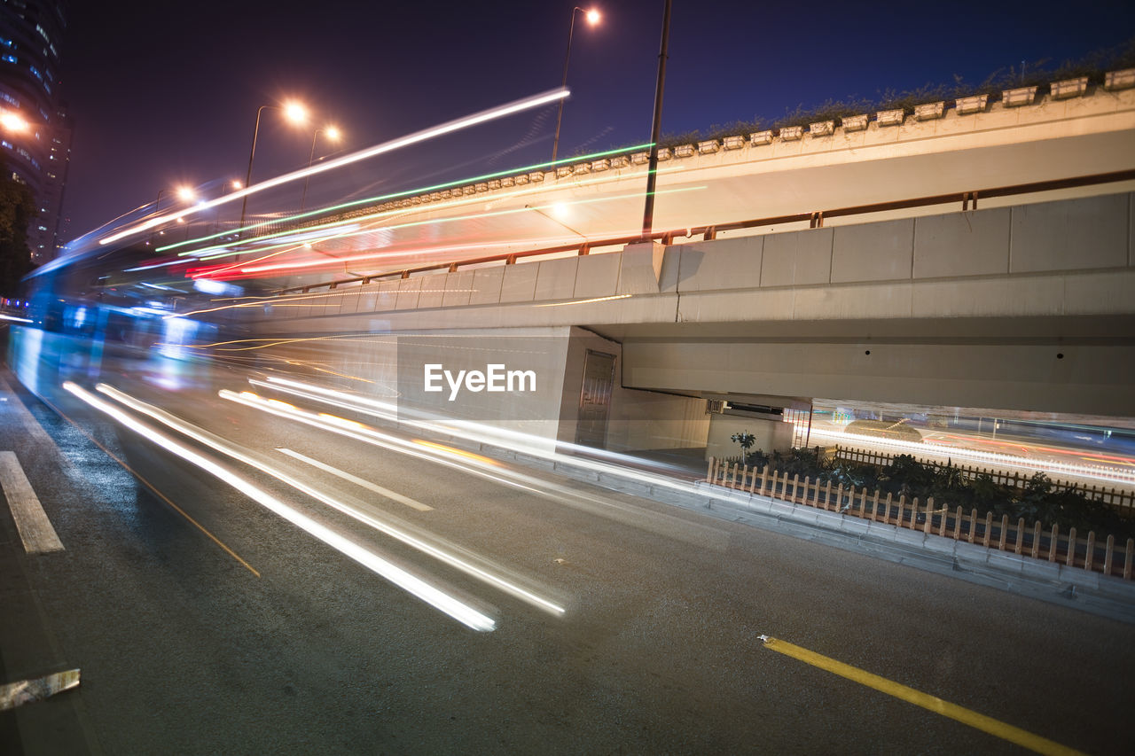 LIGHT TRAILS ON ROAD IN CITY