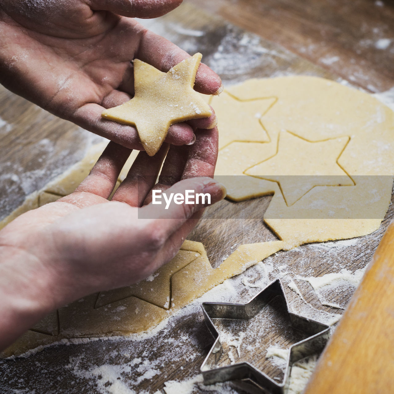 High angle view of hand holding star shape cookies on table