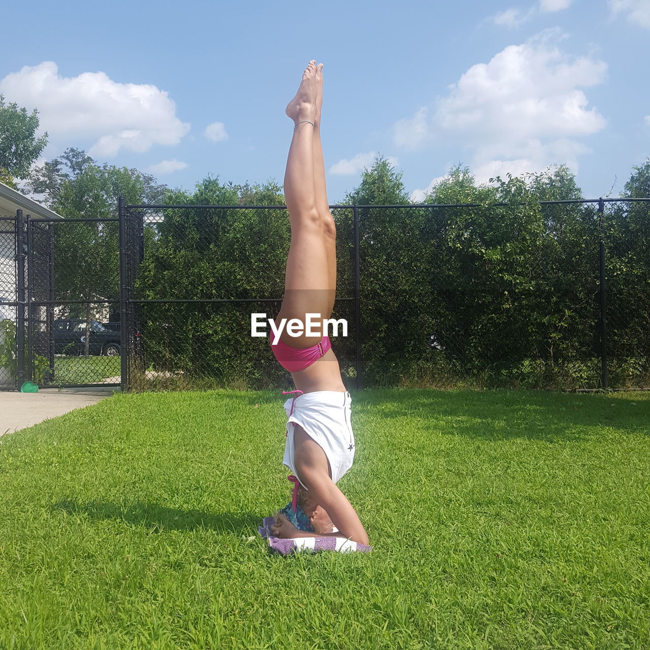 Woman doing headstand on grass
