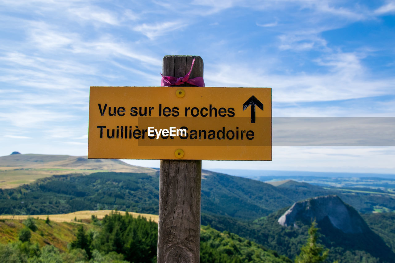 Information sign on landscape against sky