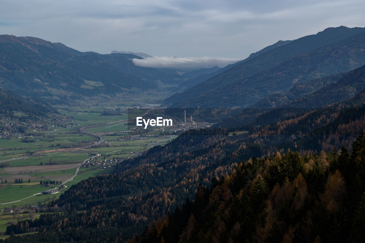 Scenic view of green landscape and mountains against sky