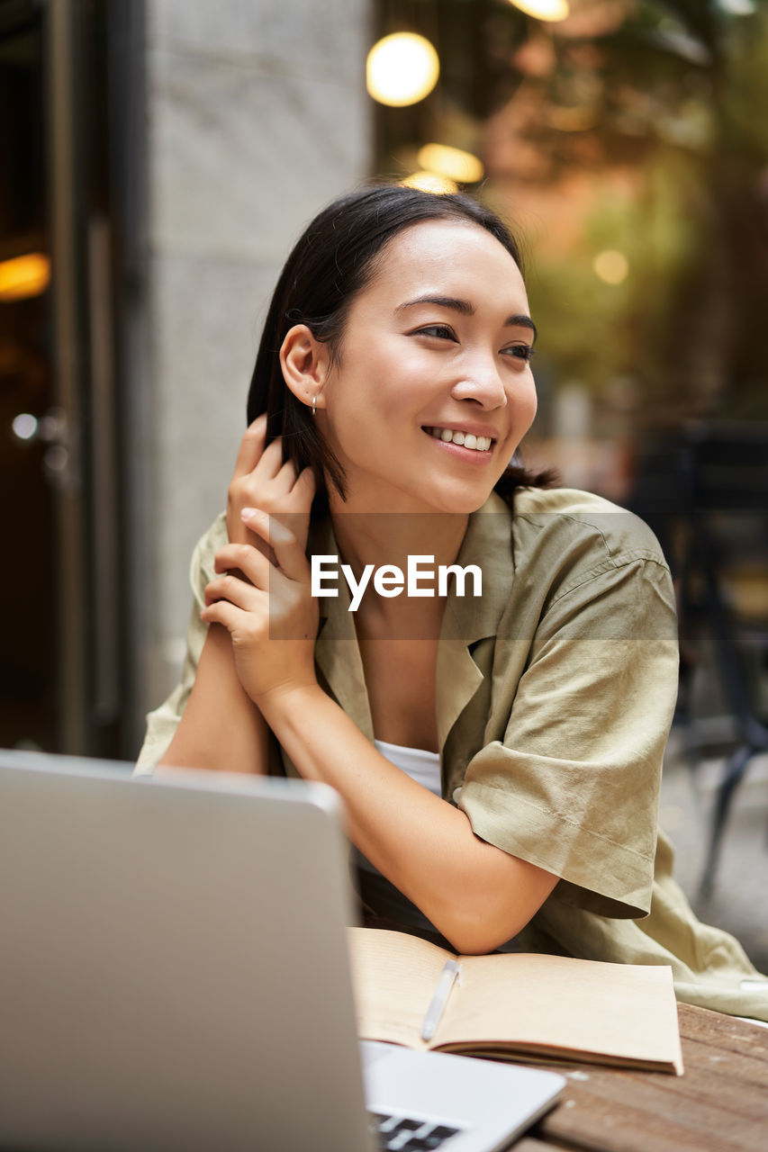 portrait of young woman using laptop at table