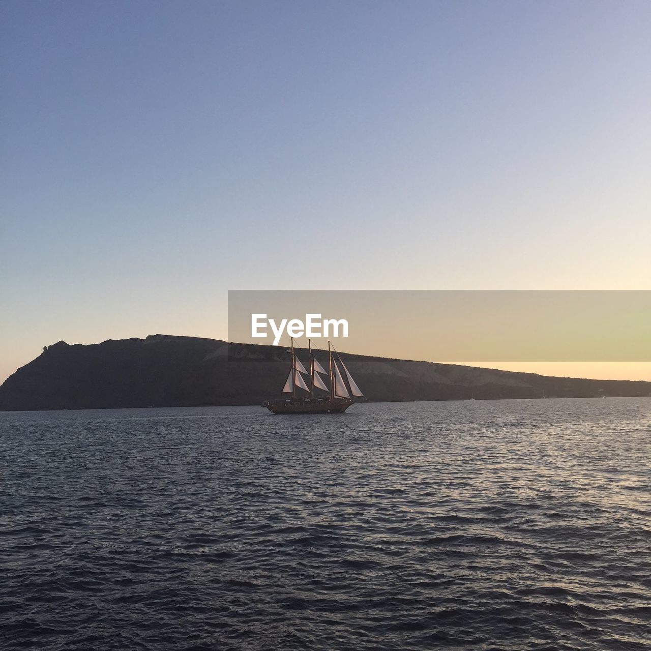 Sailboat sailing on sea against clear sky