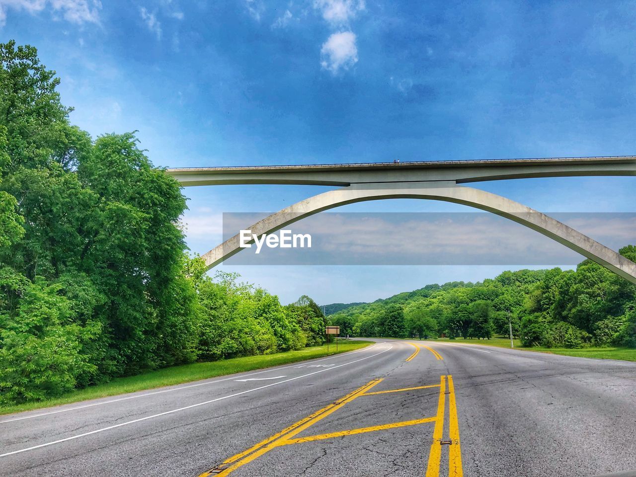 Arch bridge over road against sky