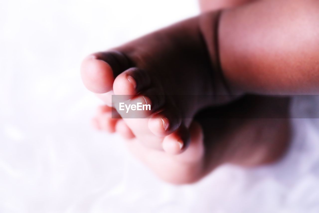 Low section of baby on bed