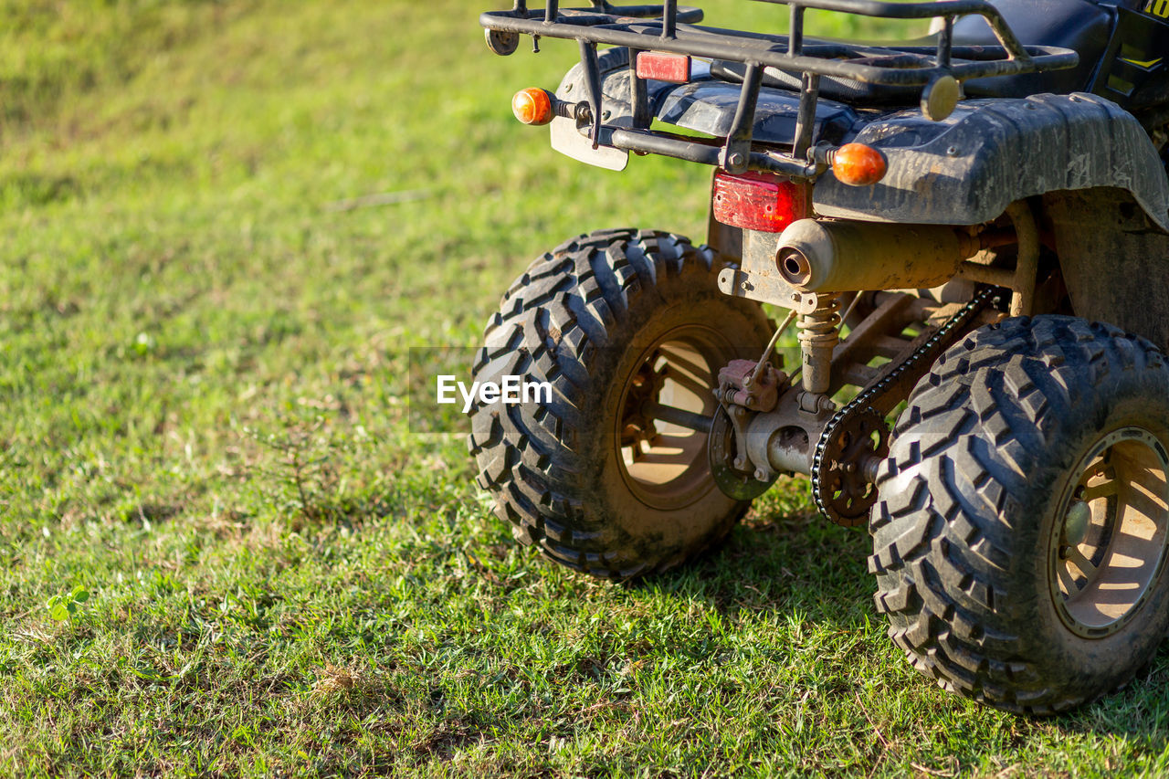 transportation, mode of transportation, grass, all-terrain vehicle, off-roading, vehicle, plant, wheel, nature, field, land vehicle, sports, off-road racing, day, land, racing, tire, lawn, car, motorsport, green, truggy, outdoors, auto part, no people, monster truck, sunlight, agricultural machinery