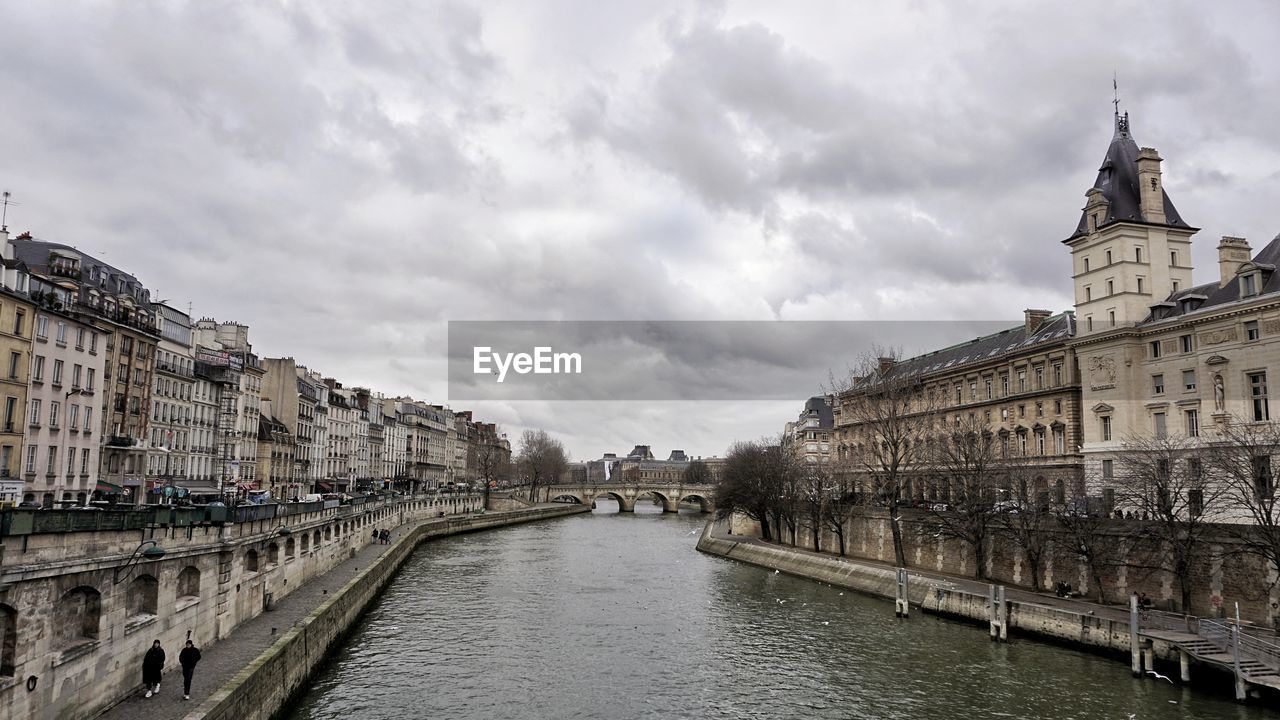 Bridge over river amidst buildings in city