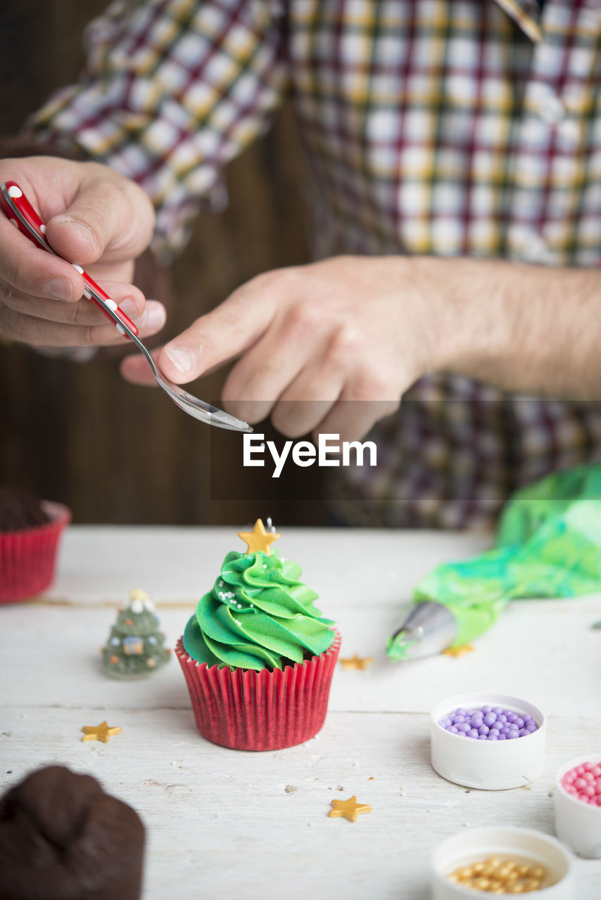 CROPPED IMAGE OF HAND HOLDING CAKE