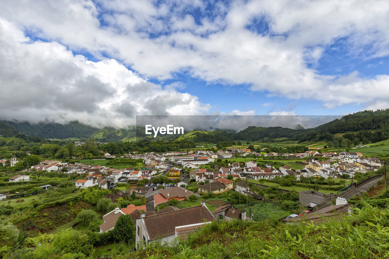 HIGH ANGLE VIEW OF TOWNSCAPE AND HOUSES AGAINST SKY