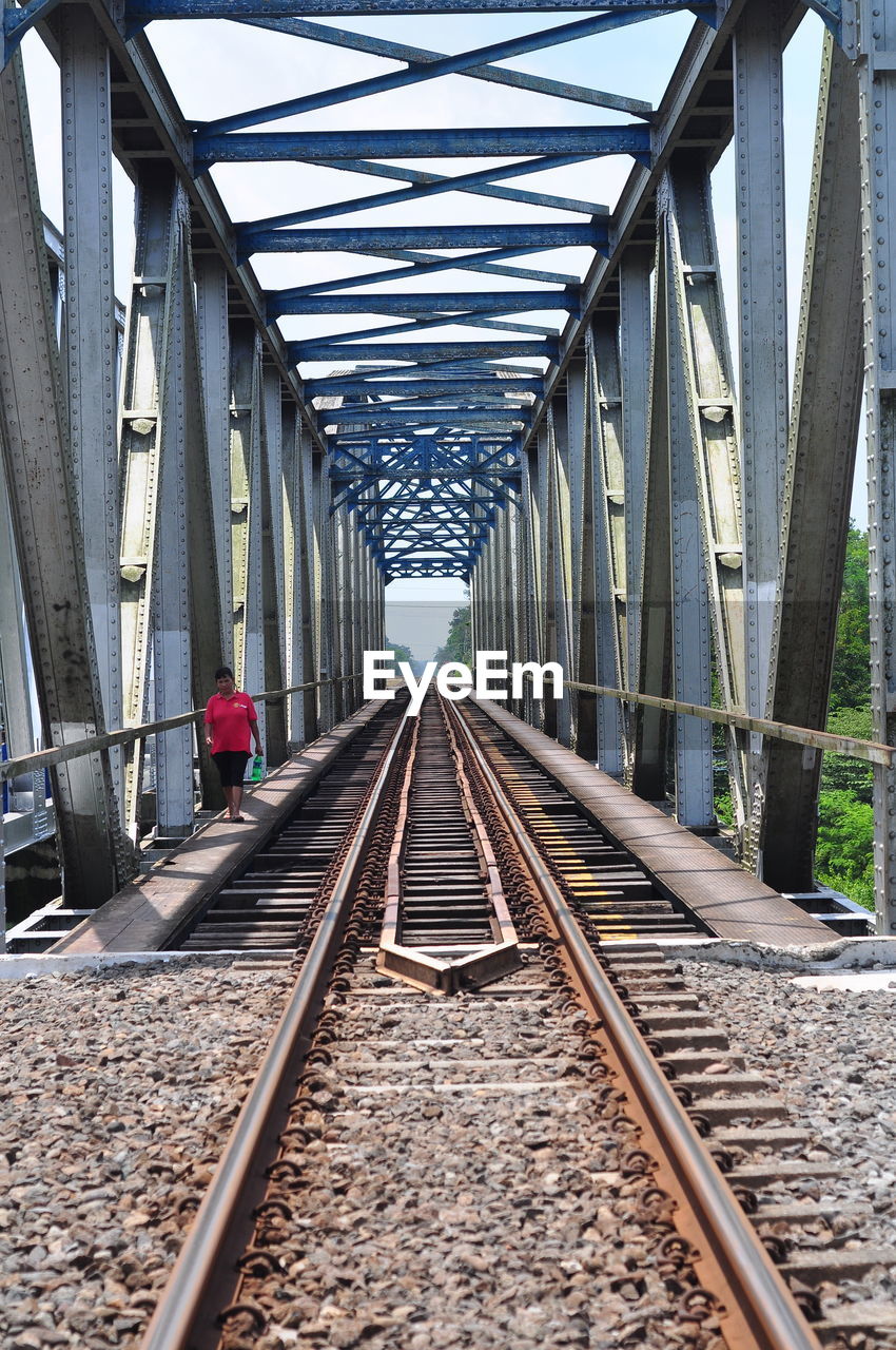 Woman walking on railway bridge