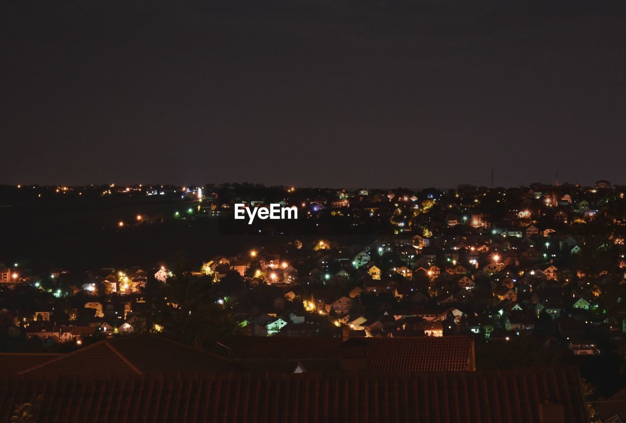 High angle view of illuminated buildings against clear sky at night